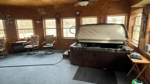 L’intérieur d’une cabane est doté d’un ventilateur de plafond, d’un jacuzzi, d’une télévision et d’une fenêtre donnant sur la forêt.
