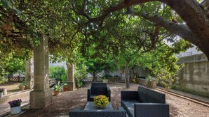 An outdoor seating area with wicker furniture and a flower centerpiece.