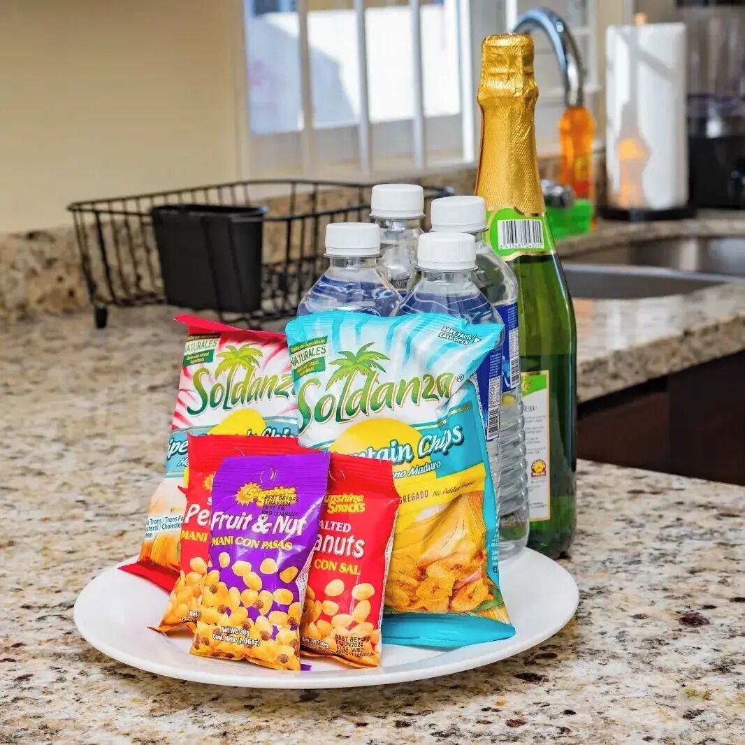 A kitchen counter with various food items and a bottle of champagne.