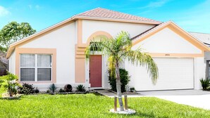 Una casa a un piano con una porta rossa, esterno beige e un garage numero 2974.