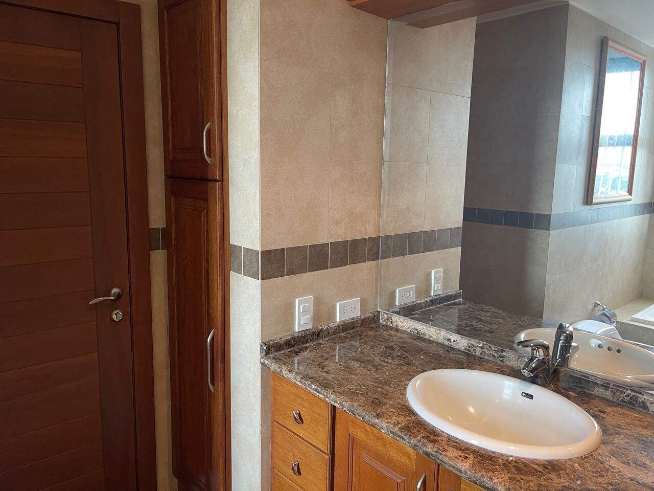 Une salle de bain avec un comptoir en marbre, un lavabo et un miroir.