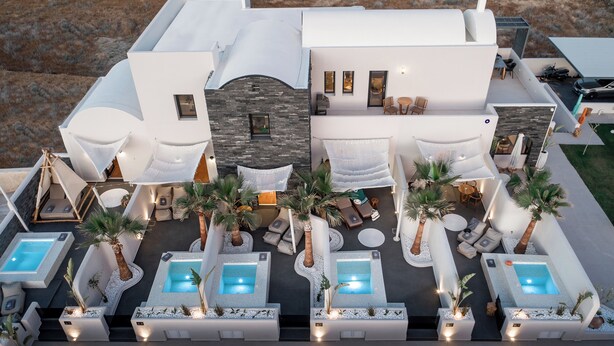 A modern hotel with multiple outdoor hot tubs, lounge areas, and a pool.