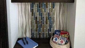 A shelf with a tissue box, a blue notebook, and a game board.