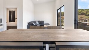 Un intérieur moderne avec une grande table à manger, un canapé et une vue sur l’extérieur.