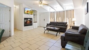 A living room with a fireplace, a sofa, a coffee table, and a television.