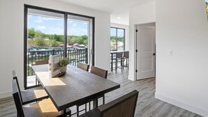 A modern interior with a dining area, large windows, and a view of the outdoors.