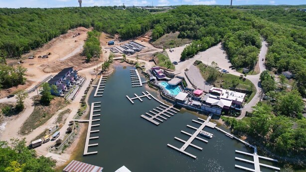 A marina with docks, a swimming pool, and a building with a sign.