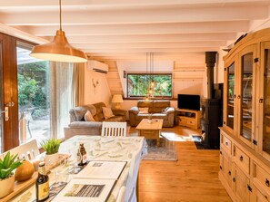 A cozy living room with a sofa, a coffee table, and a television. There is a wooden cabinet and a fireplace. - Cozy Chalet With Sauna in Lanaken (Lanaken)