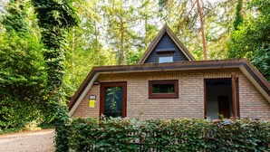 A small, single-story building with a sloped roof, a visible door, and a window. - Cozy Garden Retreat in Lanaken (Lanaken)