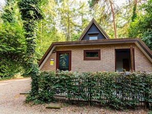 A small, single-story building with a sloped roof, a visible door, and a window. - Cozy Garden Retreat in Lanaken (Lanaken)