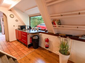 A compact kitchen with a red cabinet, a microwave, a coffee maker, and a fire extinguisher. - Cozy Garden Retreat in Lanaken (Lanaken)