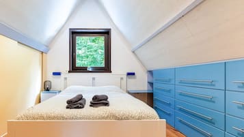 A bedroom with a bed, a window, and blue cabinets.
