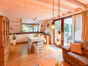 A cozy interior with a dining area, wooden cabinets, and a sofa. - Cozy Chalet With Sauna in Lanaken (Lanaken)