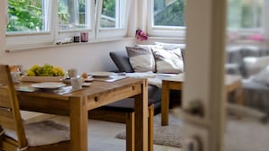 A cozy dining area with a wooden table, chairs, and a sofa. - Holiday Home Bloom 2 (Zingst)