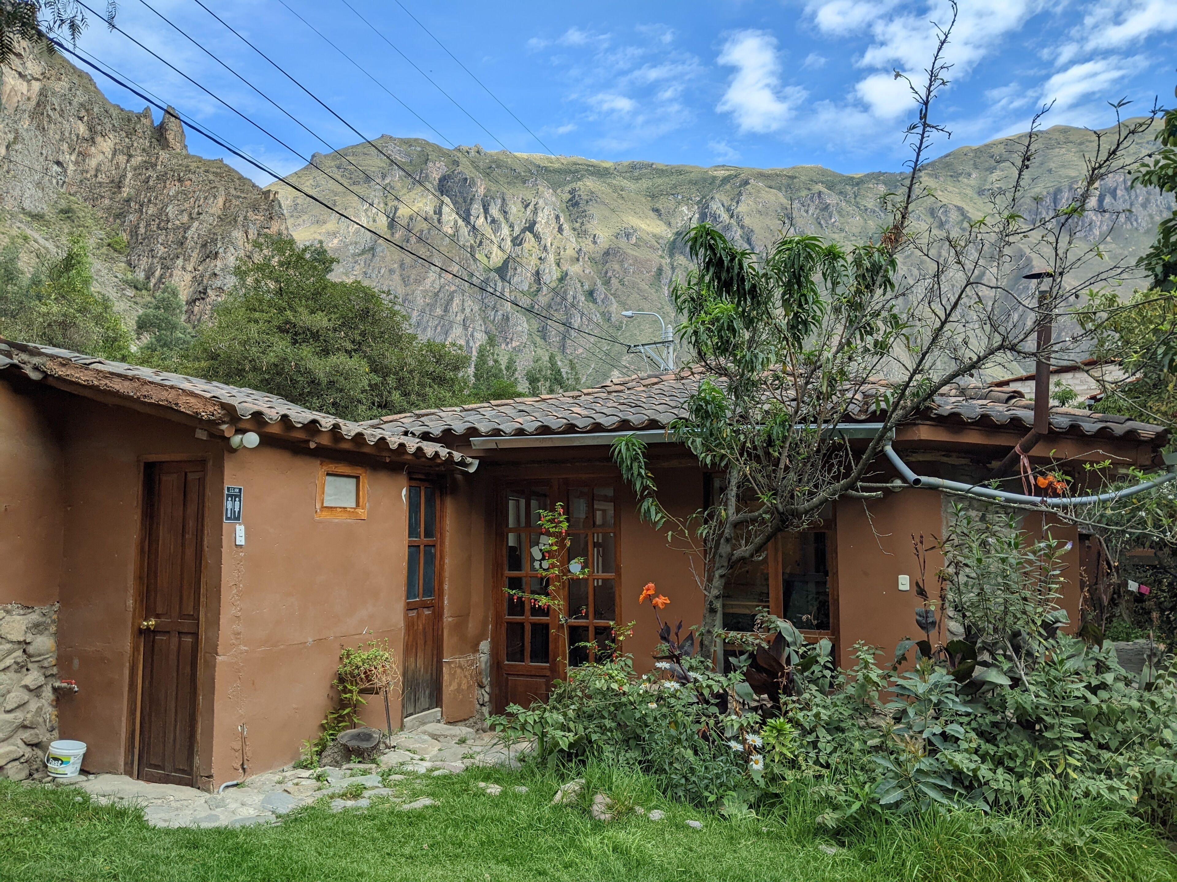 A rustic house with a tiled roof, a wooden door, and a small window.