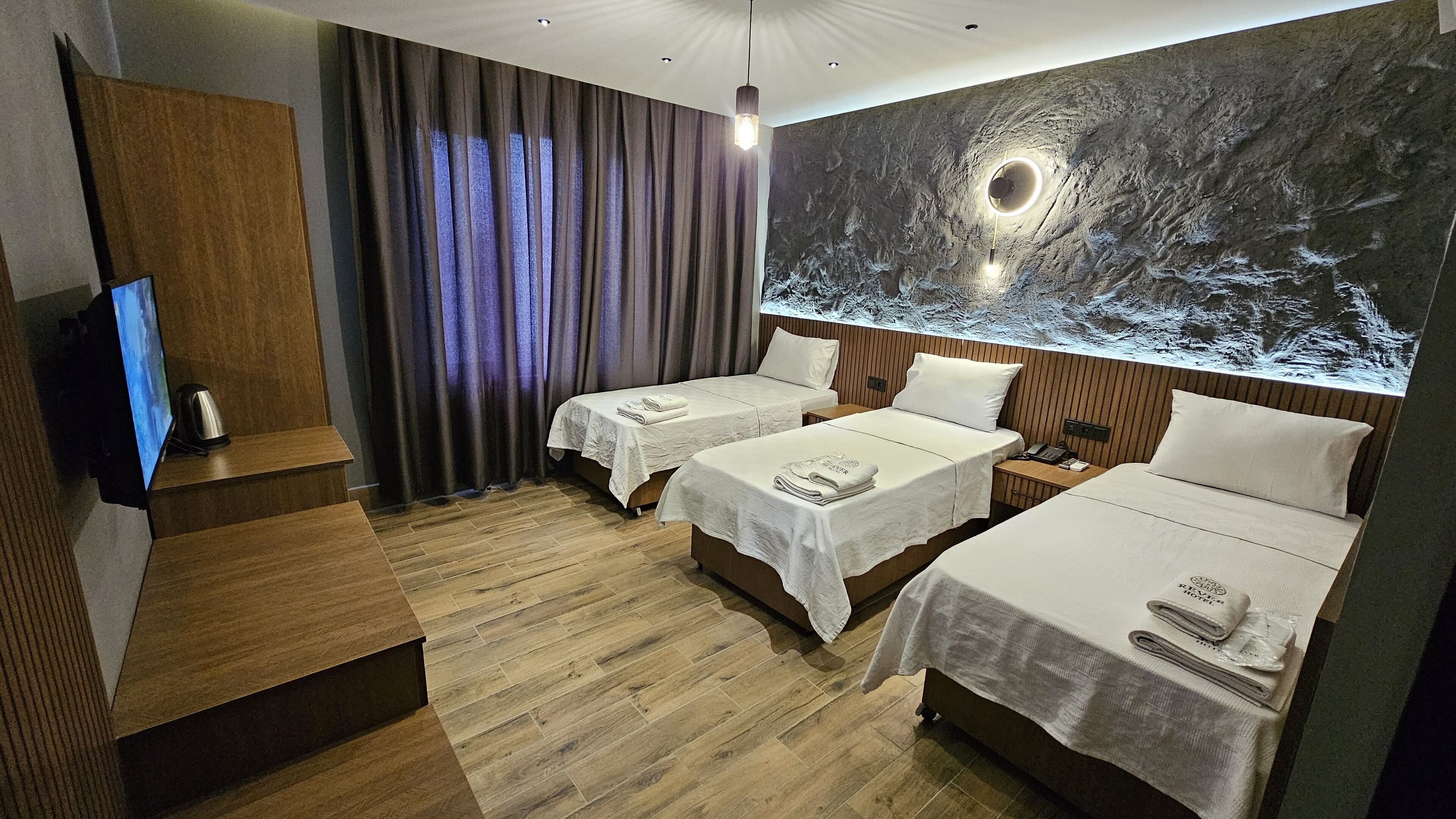 Habitación de hotel con dos camas, un televisor y un mural grande en la pared.
