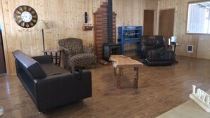 Ein Wohnzimmer mit Kamin, einer Couch, einem Sessel und einem Couchtisch.