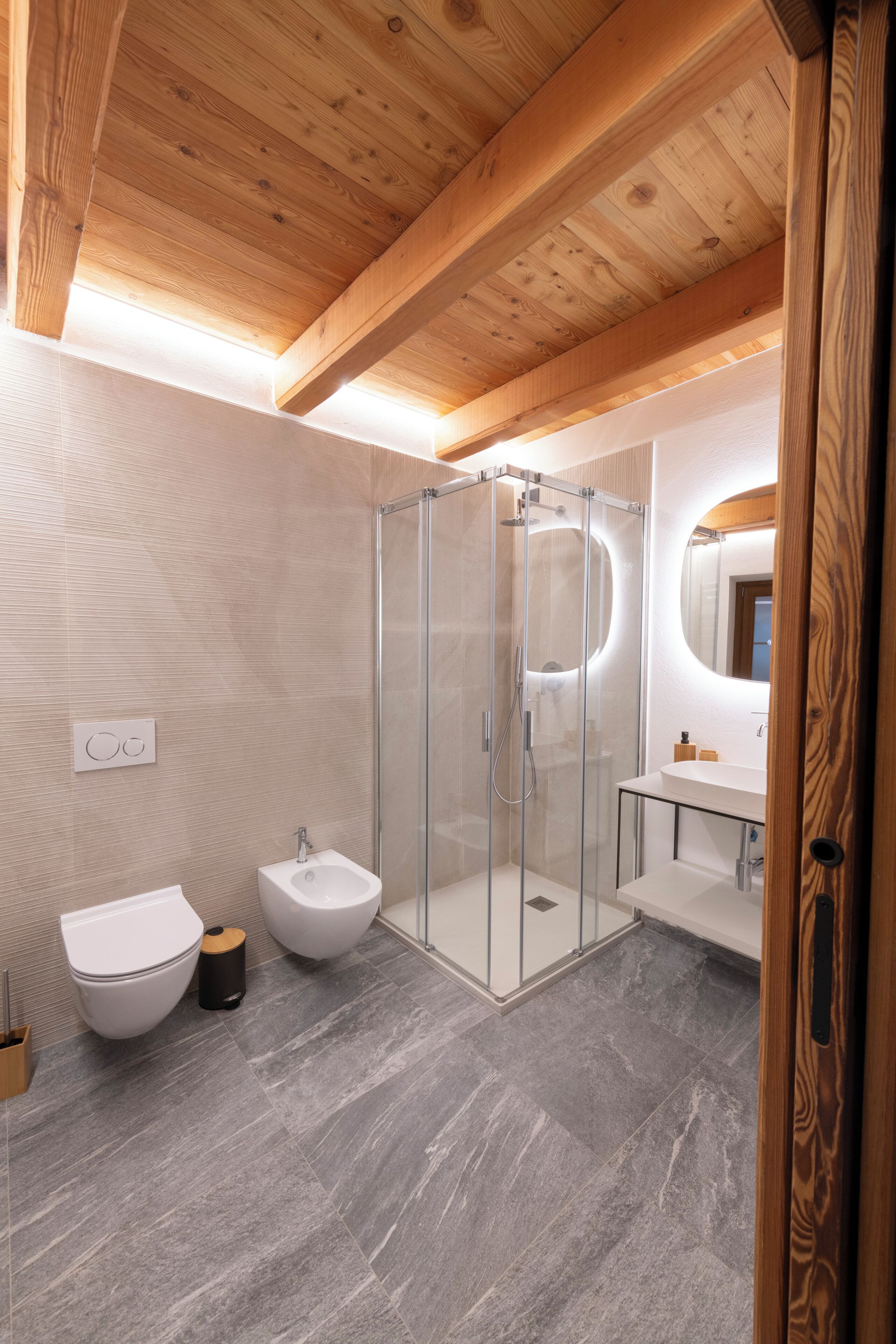 Une salle de bain moderne avec une douche à parois de verre, un lavabo blanc et des toilettes.