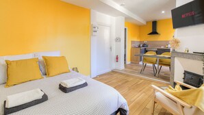 Una habitación de hotel moderna con cama, escritorio y zona de cocina.