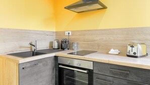 Una cocina compacta con un lavamanos, estufa y tostadora.