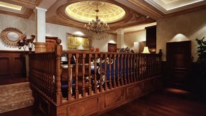 Un vestíbulo imponente con un banco de madera, un candelabro y un espejo grande.