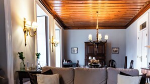 A living room with a sofa, a coffee table with magazines, a chandelier, and wall sconces. - Douro D'heart - Casa Familiar no Centro da Régua (Peso da Régua)
