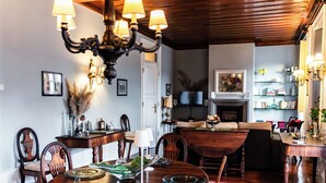 A dining area with a wooden table, chairs, and a chandelier. - Douro D'heart - Casa Familiar no Centro da Régua (Peso da Régua)