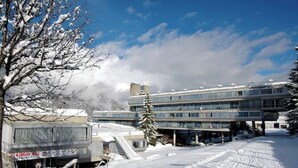 A snow-covered building with multiple floors and a parking area. - Ale 1206 Marilleva 1400, Direct access to slopes  (Marilleva 1400)