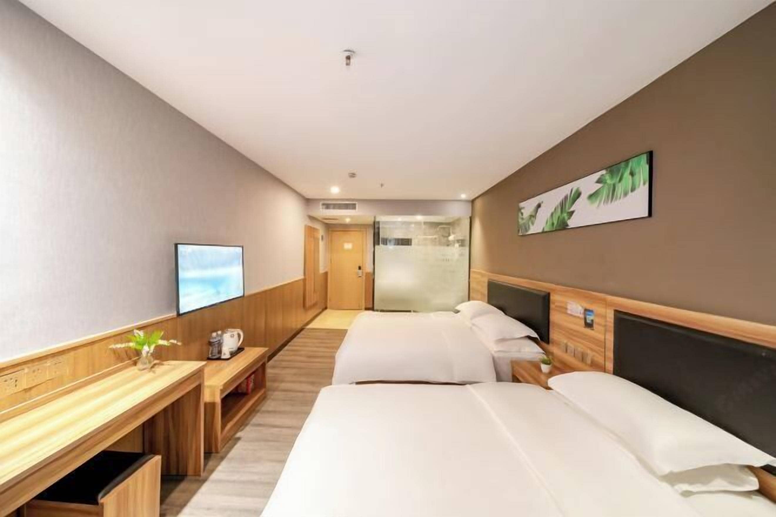 Een hotelkamer met een bed, bureau, televisie en douche.