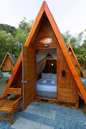 A triangular wooden structure with a bed, a chair, and a small table. - Slumber Resort Koh Chang (Ko Chang)