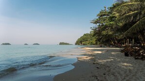 A beach with clear water, a sandy shore, and a few small islands in the distance. - Slumber Resort Koh Chang (Ko Chang)