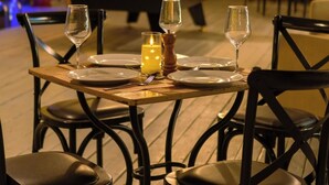 A dining table set for two with chairs, a candle, and a salt shaker. - Slumber Resort Koh Chang (Ko Chang)