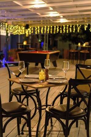 A dining table set for two with chairs, a candle, and a salt shaker. - Slumber Resort Koh Chang (Ko Chang)