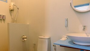 A bathroom with a toilet, a sink, a mirror, and a shower area. - Slumber Resort Koh Chang (Ko Chang)
