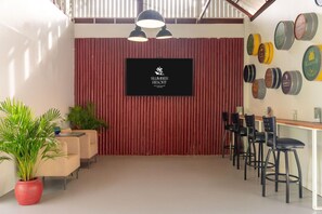 A room with a red wall, a black screen, and several stools. - Slumber Resort Koh Chang (Ko Chang)