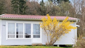 A single-story house with a red-tiled roof, white siding, and a number '119' on the side.