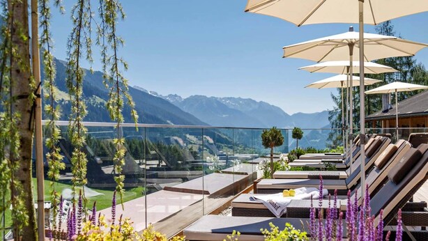 A rooftop lounge area with sun loungers, a glass balustrade, and a mountain view. - Lakeside Escape With Garden Fun (Goldberg)