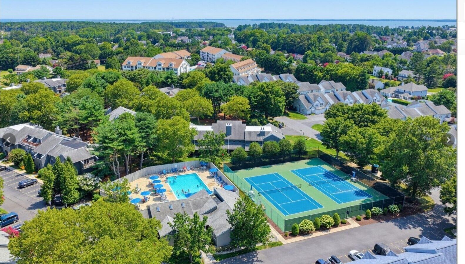 Vista aérea de una zona residencial con piscina y canchas de tenis.