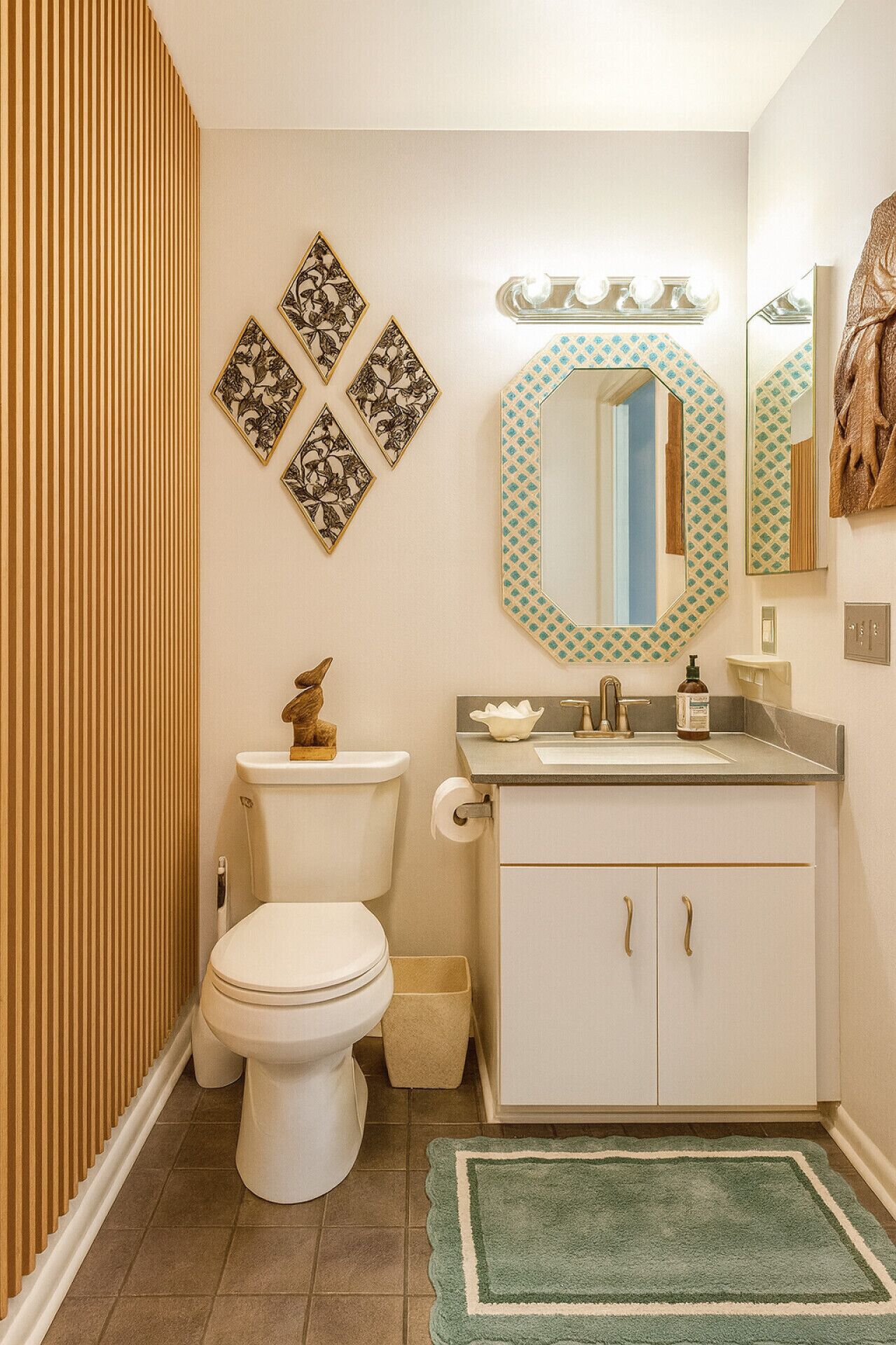 Un baño con inodoro, lavamanos y espejo.