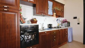 Una cocina con armarios de madera, estufa y fregadero.