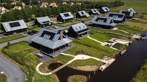 Een woonwijk met moderne huizen, een rivier en een brug.