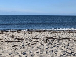 A sandy beach with waves approaching the shore. - 6 Person Holiday Home in Idestrup (Idestrup)