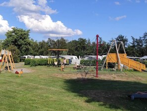A playground with swings, a slide, and a climbing structure.