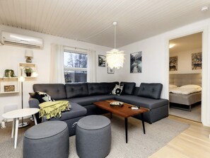 A modern living room with a sectional sofa, a coffee table, and a round rug. - 6 Person Holiday Home in Idestrup (Idestrup)
