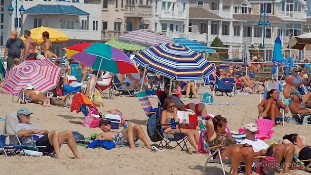 A beach with people relaxing under colorful umbrellas, beach chairs, and sun loungers. - SUMMER FUN IN A 3BED/2BATH SINGLE FAMILY HOME! (Belmar)