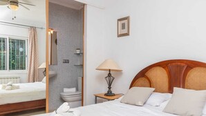 Une chambre d’hôtel avec un lit, une table de chevet avec une lampe, une fenêtre avec des rideaux et une vue sur l’extérieur.