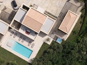 Ein Wohngebäude mit Schwimmbad, Sitzgelegenheiten im Freien und einem eingezäunten Garten.