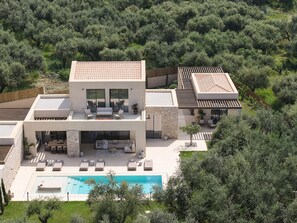 A modern two-story house with a swimming pool, outdoor seating, and a lush garden. - Valerozo Villa Maestosa - Pool, Jacuzzi & steps to the beach (Ionian Islands, Zakynthos)