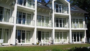 A multi-story hotel with balconies, large windows, and outdoor seating areas. - Villa Granitz Apartment (Göhren)