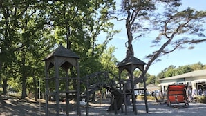 A playground with wooden structures and a gravel ground. - Villa Granitz Apartment (Göhren)